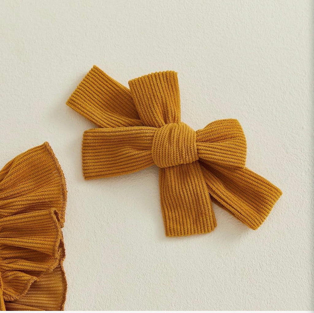 Golden mustard ribbed corduroy romper with Homemade Rolls embroidery and matching bow headband, styled with fall props